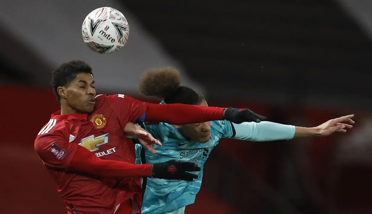 Penyerang Manchester United, Marcus Rashford dan bek Liverpool, Rhys Williams melompat saat  berebut bola dalam laga putaran keempat Piala FA di Stadion Old Trafford, Senin dinihari WIB (25/1/2021). Manchester United atau MU singkirkan Liverpool usai menang 3-2. (Phil Noble/Pool via AP)