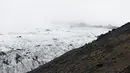 Turis berjalan saat mengunjungi perairan Gletser Solheimajokull, Islandia, Jumat (16/10).  Pemanasan global menyebabkan gletser Solheimajokull mencair hingga 1 km sejak pengukuran tahunan pada 1931. (AFP PHOTO/POOL/Thibault Camus)