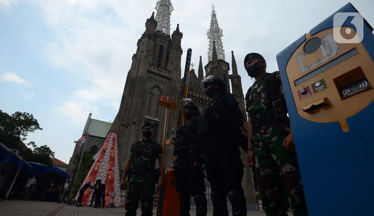 Personel Brimob dan tentara berjaga di pintu masuk Gereja Katedral, Jakarta, Jumat (24/12/2021). Sebanyak 100 personel diturunkan untuk mengamankan ibadah Natal 2021 di Gereja Katedral. (merdeka.com/Imam Buhori)