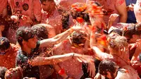 Para peserta saling melempar tomat dalam festival La Tomatina berlangsung di desa Bunol, Spanyol, Rabu (30/8). Anggaran yang dikeluarkan untuk La Tomatina adalah 36.000 euro atau setara dengan 570 juta rupiah. (Alberto Saiz/AP)