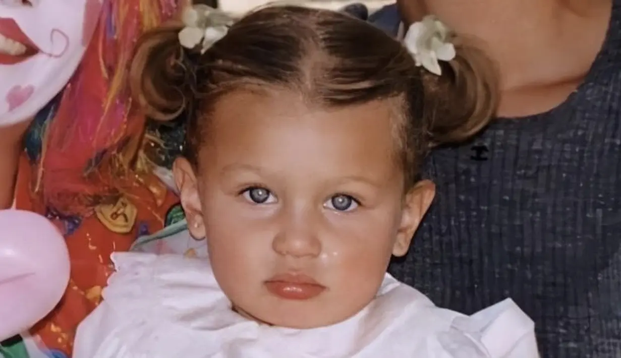 Gemasnya Bella Hadid saat masih Balita dengan gaya rambut kuncir duanya. Ia tampil mengenakan dress putihnya. @bellahadid