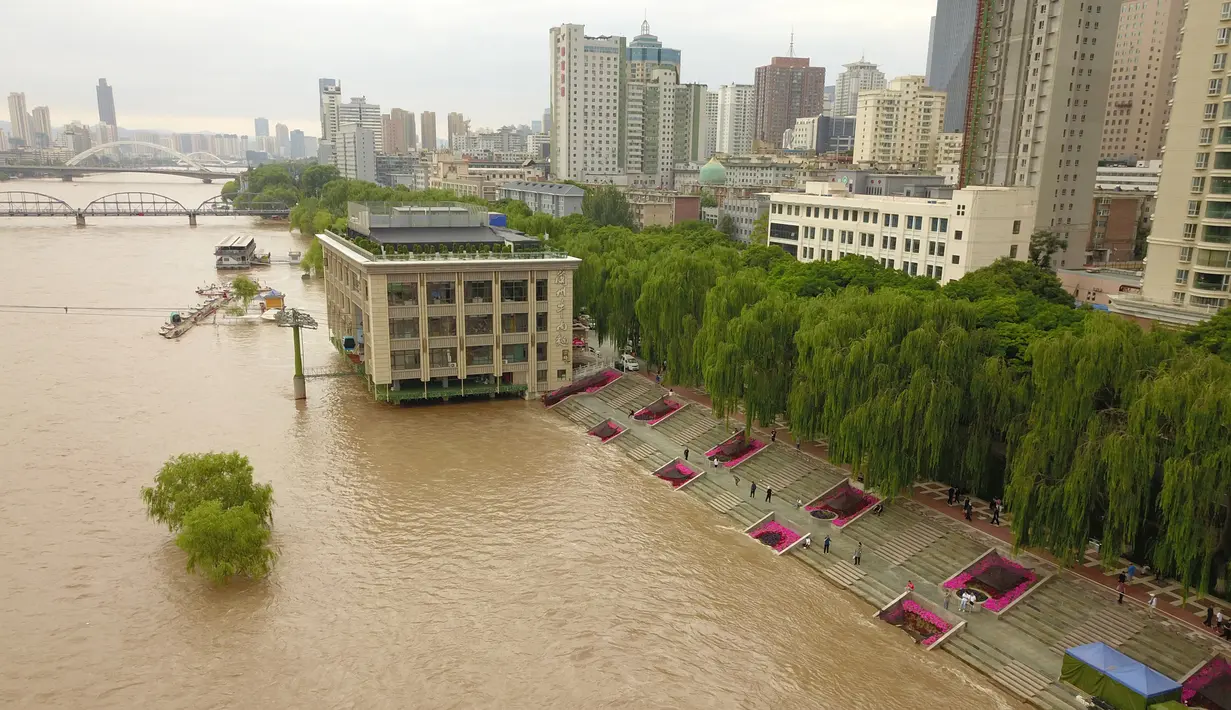 Foto dari udara memperlihatkan dermaga yang terendam banjir Sungai Kuning di Chengguan, Kota Lanzhou, Provinsi Gansu, China, Selasa (21/7/2020). Stasiun hidrologi Lanzhou di Sungai Kuning menyaksikan banjir kedua tahun ini dengan aliran air mencapai 3.000 meter kubik per detik. (Xinhua/Fan Peishen)