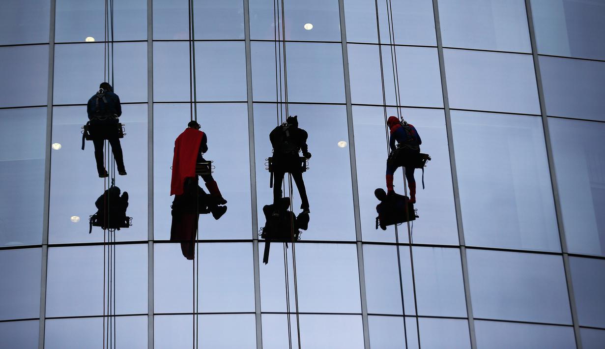 Tokoh superhero Captain America, Superman, Batman dan Spiderman membersihkan kaca jendela kamar di sebuah rumah sakit di Birmingham, Alabama, Rabu (11/10). Mereka bergelantungan di luar jendela dengan mengenakan kostum. (AP Photo/Brynn Anderson)