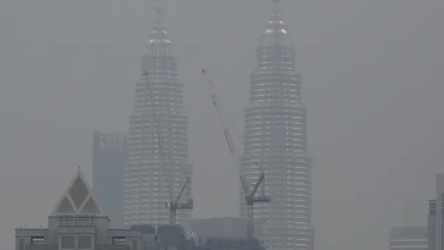 Diselimuti Kabut Asap, Warga Malaysia Beraktivitas Pakai Masker