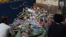 Pemulung membersihkan botol-botol plastik yang diambil dari tumpukan sampah di Pintu Air Manggarai, Jakarta, Jumat (26/4). Selanjutnya, botol-botol plastik bekas minuman kemasan ini akan dijual ke pengepul. (Liputan6.com/Helmi Fithriansyah)