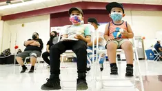 Oliver Estrada, 5, (kiri depan) menunggu dengan saudaranya Adriel, 2, usai menerima dosis pertama vaksin COVID-19 Pfizer di Adelante Healthcare, SD Joseph Zito, Phoenix, Amerika Serikat, 6 November 2021. AS gelar vaksinasi COVID-19 untuk anak-anak berusia 5-11 tahun. (AP Photo/Ross D. Franklin)