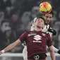 Gelandang Torino Sasa Lukic (depan) berebut bola dengan gelandang Juventus Manuel Locatelli dalam pekan 26 Serie A Liga Italia di Allianz Stadium, Sabtu (19/2/2022) dinihari WIB. Juventus ditahan imbang Torino 1-1. (Filippo MONTEFORTE / AFP)