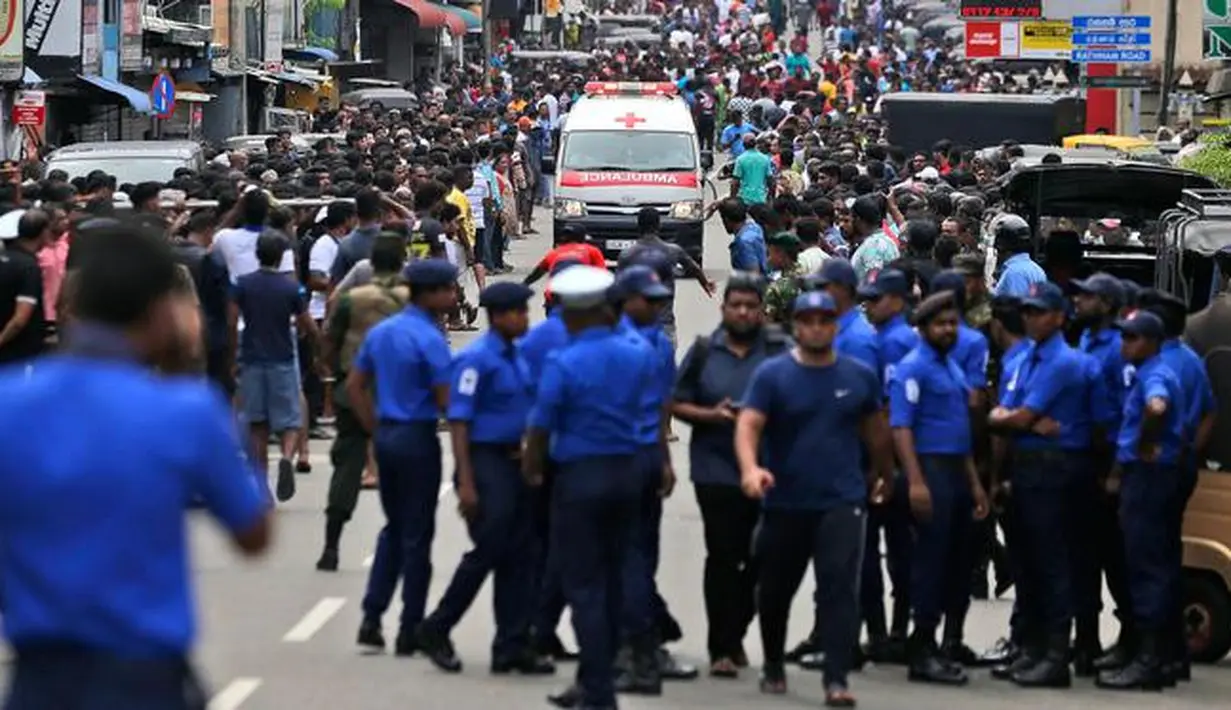 Polisi mensterilkan jalan saat sebuah ambulans melaju membawa korban ledakan gereja di Kochchikade, Kolombo, Sri Lanka, Minggu (21/4). Sekitar 99 orang dilaporkan tewas dalam ledakan di tiga gereja dan tiga hotel di Sri Lanka. (AP Photo/Eranga Jayawardena)