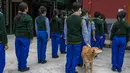 Seekor anjing berdiri di antara anak-anak Tibet di pengasingan selama pertemuan pagi di Sekolah Hari Desa Anak-anak Tibet di Dharmsala, India (24/3/2022). Kehidupan sekolah perlahan kembali normal setelah sempat terganggu akibat pandemi COVID-19. (AP Photo/Ashwini Bhatia)