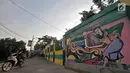 Aktivitas warga di dekat mural Betawi di Kampung Pitung, Marunda, Jakarta, Senin (2/7). Dibuatnya Mural ini bertujuan mempercantik kawasan Kampung Pitung yang sebelumnya terkesan kumuh sekaligus menarik minat wisatawan. (Merdeka.com/Iqbal S. Nugroho)