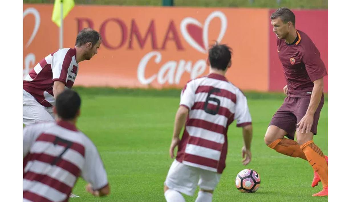 Edin Dzeko (kanan) berusaha melewati hadangan para pemain AC Pinzolo pada laga uji coba di Pinzolo, Italia (13/7/2016). AS Roma menang 16-0. (Bola.com/asroma.com)