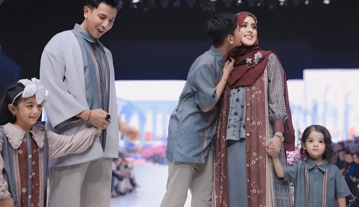 Fairuz mengenakan busana Shi by Shireen bersama suaminya dan ketiga anak-anaknya. Fairuz mengenakan long outer kemeja dipadukan blouse dan skirt abu-abu. [@shireensungkar]