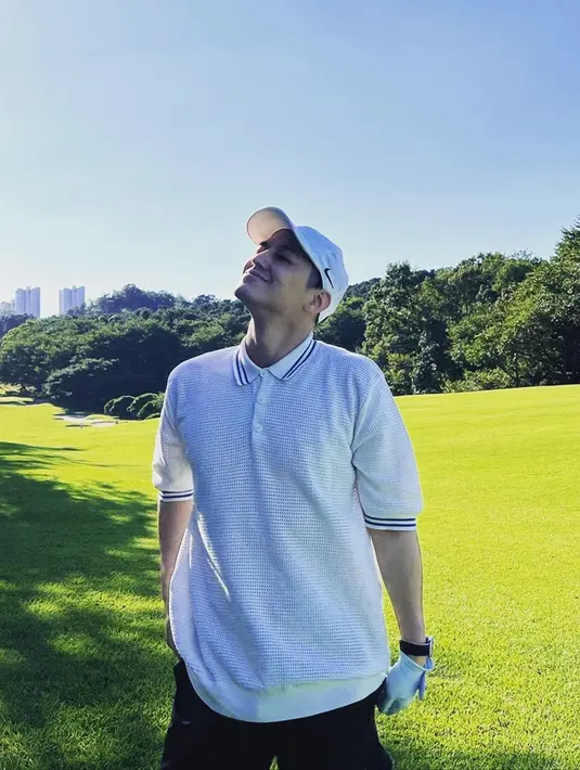 Ia pun tampak santai memakai kaos putih saat bermain golf. Dirinya pun hanya memadukan penampilannya dengan topi serta sarung tangan senada. (Liputan6.com/IG/@k.kbeom)
