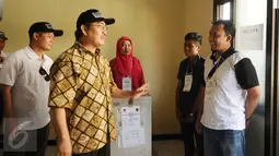 Ketua DKPP, Jimly Asshiddiqie (kedua kiri) berbincang dengan petugas KPPS di TPS 14 Beji Timur Kota Depok, Jawa Barat, Rabu (9/12/2015). Jimly mengecek langsung pelaksanaan Pilkada di sejumlah TPS yang ada di Kota Depok. (Liputan6.com/Helmi Fithriansyah)