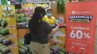 Tampak seorang pengunjung sedang melakukan transaksi menggunakan ShopeePay sembari menikmati promo Cashback 60% di sentra kuliner Tiara Dewata