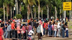Puluhan pengunjung rela antri untuk naik kereta wisata di sekitar areal Monumen Nasional, Jakarta, Jumat (1/1/2016). Hari libur tahun baru 2016 dimanfaatkan ribuan warga untuk berwisata di kawasan Monumen Nasional. (Liputan6.com/Helmi Fithriansyah)