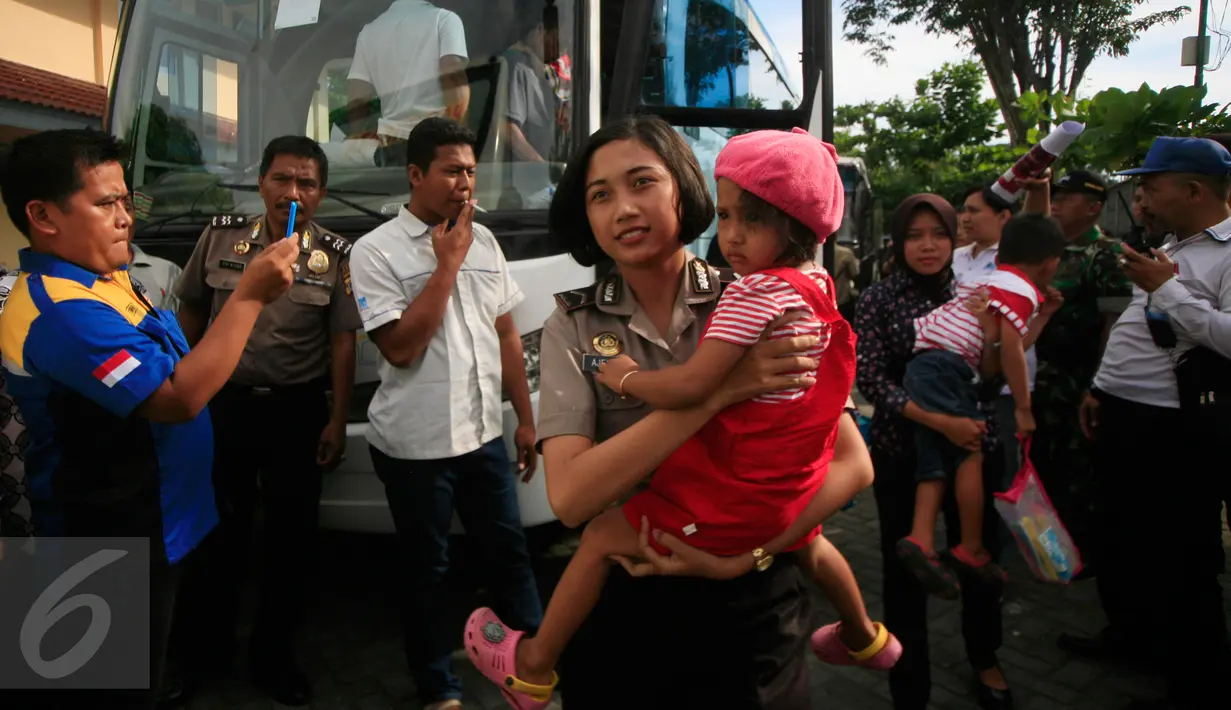 Seorang Polwan menggendong salah satu anak eks anggota Gafatar yang tiba di Penampungan Youth Center, Sleman, Yogyakarta, Jumat (29/1). Mereka sebelumnya ditampung di wisma Haji Donohudan, Boyolali untuk pendataan kependudukan (Foto: Boy Harjanto)
