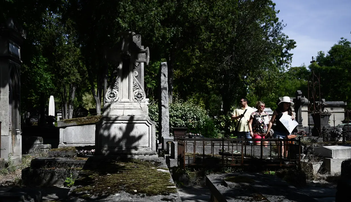Turis mengunjungi pemakaman Pere Lachaise di Paris (22/7/2019). Pemakaman ini paling banyak didatangi wisatawan di dunia. Artis dan banyak tokoh terkenal dimakamkan di sini. (AFP Photo/Philippe Lopez)