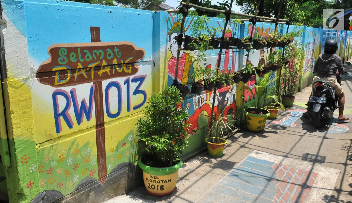 Kondisi sebuah gang yang dihiasi warna-warni mural di Kelurahan Rorotan, Jakarta, Kamis (29/3). Mural ini bertujuan mempercantik serta menambah kesan asri gang selebar 2 meter tersebut. (Merdeka.com/Iqbal S Nugroho)