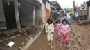 Anak-anak berjalan melintasi lumpur usai banjir bandang melanda Kampung Cibuntu, Desa Pasawahan, Kecamatan Cicurug, Sukabumi, Jawa Barat, Selasa (22/9/2020). Data sementara puluhan bangunan rusak berat, 12 rumah hanyut, dan dua korban hilang masih dicari. (merdeka.com/Arie Basuki)