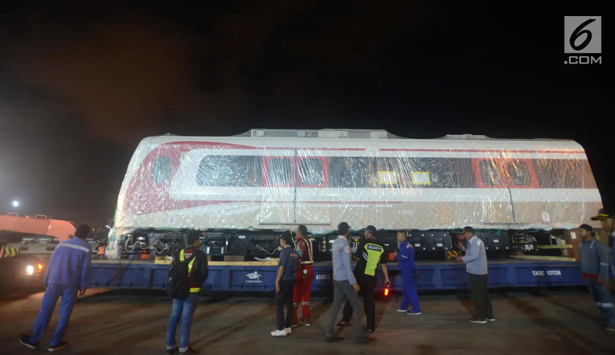 Pekerja dibantu alat berat menarik gerbong kereta ringan/Light Rail Transit (LRT) di Pelabuhan Car Terminal, Tanjung Priok, Jakarta, Jumat (13/4). Dua gerbong kereta LRT yang diangkut itu merupakan yang pertama tiba di Jakarta. (Merdeka.com/Imam Buhori)
