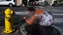 Stephanie Williams, mendinginkan diri dengan air dari hidran di daerah Skid Row di Los Angeles, Rabu (31/8/2022). Peringatan panas berlebihan meluas ke seluruh California Selatan dan utara ke Central Valley pada Rabu, diperkirakan akan menyebar ke California Utara di akhir minggu. (AP Photo/Jae C.Hong)