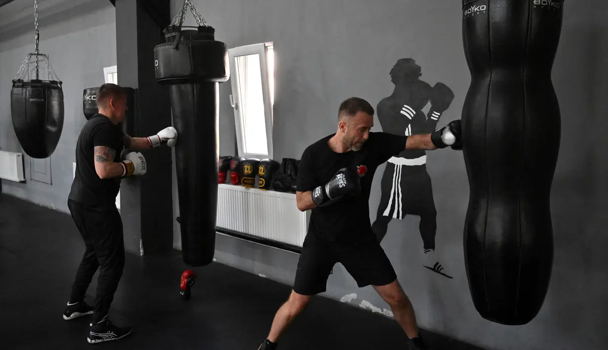 Petinju amatir berlatih di All Stars Boxing Club, Kiev, Ukraina, 10 Mei 2022. Suara hip hop bercampur dengan bunyi pukulan tinju saat sekelompok petinju melepaskan stres terpendam di tengah perang Ukraina. (Sergei SUPINSKY/AFP)