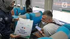 Petugas memberikan bingkisan kepada penumpang KA Taksaka di Stasiun Gambir, Jakarta, Sabtu (4/8/2021). Dalam rangka memperingati hari pelanggan nasional, PT KAI Daop 1 Jakarta membagikan ratusan bingkisan kepada penumpang kereta api. (Liputan6.com/Faizal Fanani)