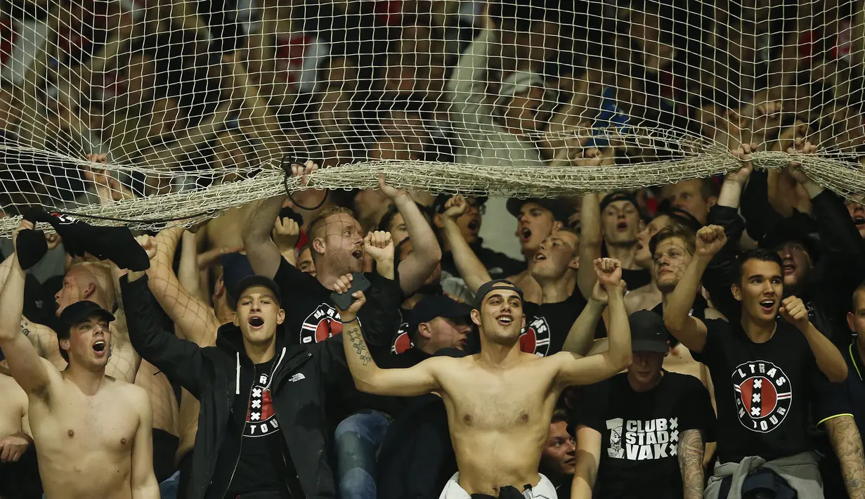 Suporter Ajax Amsterdam melakukan selebrasi usai laga semifinal Liga Europa di Stadion Parc Olympique Lyonnais, Kamis (12/05/2017). Lyon menang dengan skor 3-1. (EPA/Guillaume Horcajuelo)