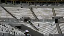 Pekerja membersihkan tribun Lusail Stadium di Lusail, Qatar, 28 Maret 2022. Stadion berkapasitas 80 ribu penonton yang terletak di pinggiran Ibu Kota Doha ini akan menjadi tuan rumah final Piala Dunia 2022 pada bulan Desember mendatang. (GABRIEL BOUYS/AFP)