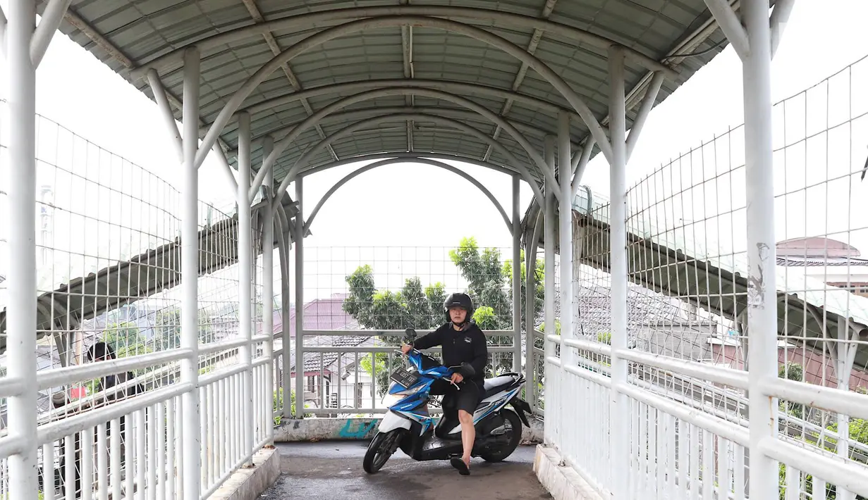 Pemotor melintasi jembatan penyeberangan orang (JPO) di kawasan Pasar Minggu, Jakarta, Rabu (24/4). Kurangnya kesadaran akan tertib berlalu lintas menyebabkan para pemotor itu nekat melintasi JPO, meskipun dapat merugikan hak pejalan kaki. (Liputan6.com/Immanuel Antonius)