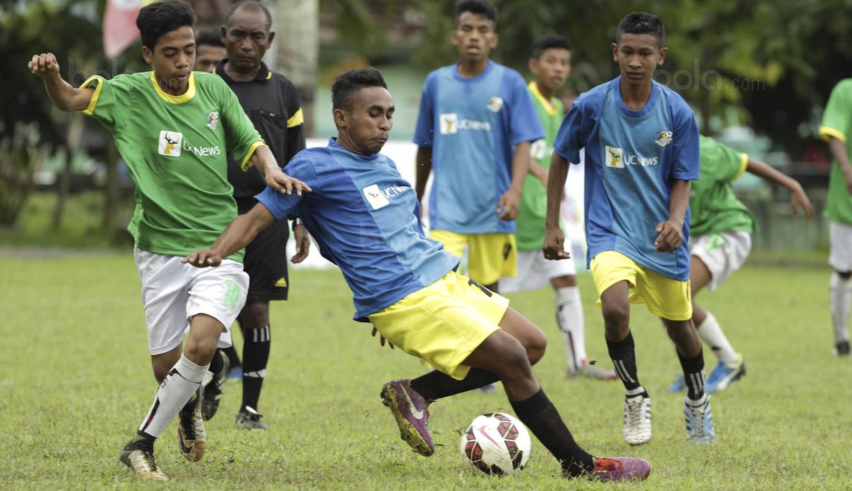 Pemain SSB Hatu berebut bola dengan pemain SSB Maehanu pada semifinal turnamen Liga Remaja UC News di Lapangan Masariku Yonif 733, Ambon, Rabu (29/11/2017). (Bola.com/Peksi Cahyo)