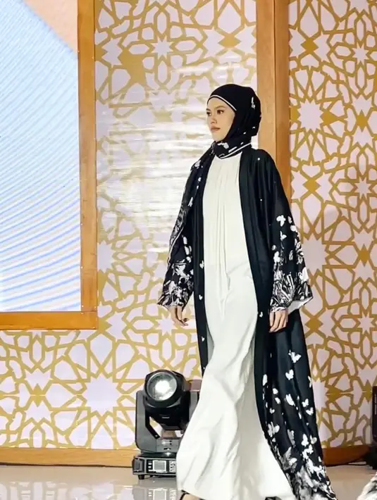 <p>Busana dengan model layering seperti gamis polos yang dipadukan dengan long outer warna hitam bisa memberikan kesan elegan pada tampilan. (Instagram/mandjha.ivangunawan).</p>