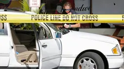 Polisi memeriksa kendaraan di tempat parkir Club Blu setelah insiden penembakan di Fort Myers, Florida, Senin (25/7). Dua orang tewas dalam serangan penembakan di klub malam tersebut yang dilaporkan sebagai tempat pesta untuk remaja. (REUTERS/Joe Skipper)