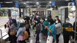 Sejumlah penumpang menunggu bus di Halte Transjakarta Gelora Bung Karno, Jakarta, Kamis (21/10/2021). PT Transportasi Jakarta (Transjakarta) mulai memberlakukan kapasitas angkut pelanggan sebesar 100 persen mulai hari ini. (Liputan6.com/Herman Zakharia)