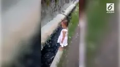 Akibat keteledoran sang ibu, bocah perempuan nyungsep ke got penuh lumpur.