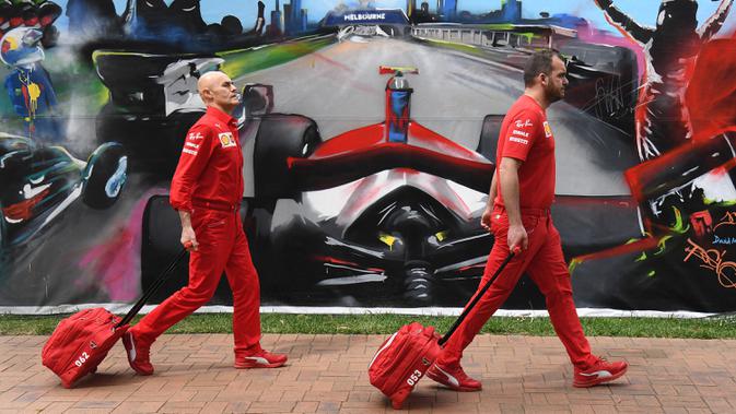 Anggota tim Ferrari tiba untuk mengepak peralatan mereka setelah Formula 1 Australia dibatalkan di Melbourne, Jumat (13/3/2020). F1 Australia batal digelar karena virus corona COVID-19. (William WEST/AFP)