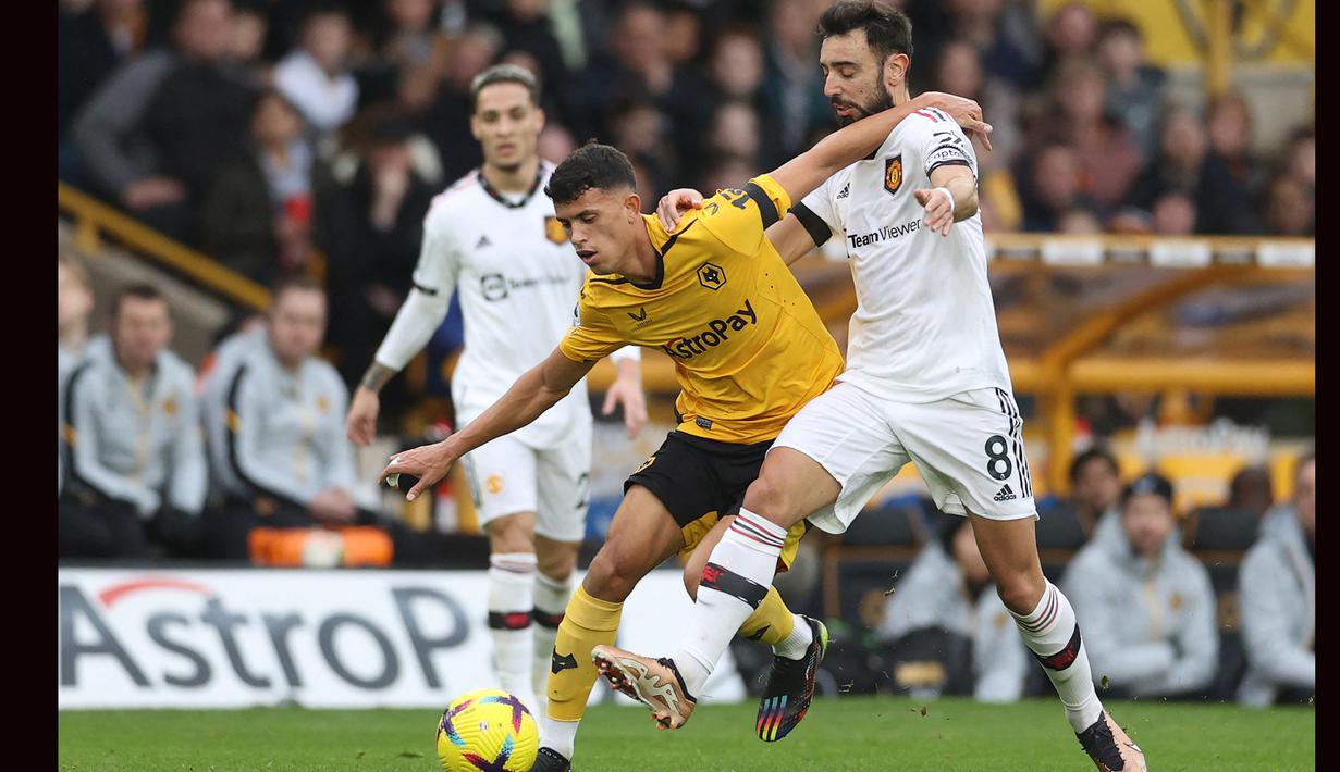 Gelandang Wolverhampton Wanderers, Matheus Nunes (kiri) berebut bola dengan gelandang Manchester United, Bruno Fernandes pada laga Liga Inggris 2022/2023 di Molineux Stadium, Wolverhampton (31/12/2022). Matheus Nunes sempat ditawar Liverpool pada bursa transfer Januari 2023, namun sang pemain nyatanya tetap berseragam Wolverhampton Wanderers hingga kini. Bisa jadi Liverpool kembali berusaha mendatangkannya musim depan karena mmepunyai pengalaman saat mendatangkan Diogo Jota yang notabene sama-sama pemain Wolverhampton asal Portugal. (AFP/Adrian Dennis)