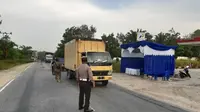 Personel Polresta Pekanbaru memeriksa kendaraan yang masuk ke perbatasan Pekanbaru selama pemberlakuan PSBB. (Liputan6.com/M Syukur)