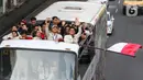 Para atlet Indonesia yang berlaga di Olimpiade Paris 2024 mengibarkan bendera Merah Putih saat berada di atas bus yang melintas dalam pawai di kawasan Bundaran HI, Jakarta, Kamis (15/8/2025). (Liputan6.com/Herman Zakharia)