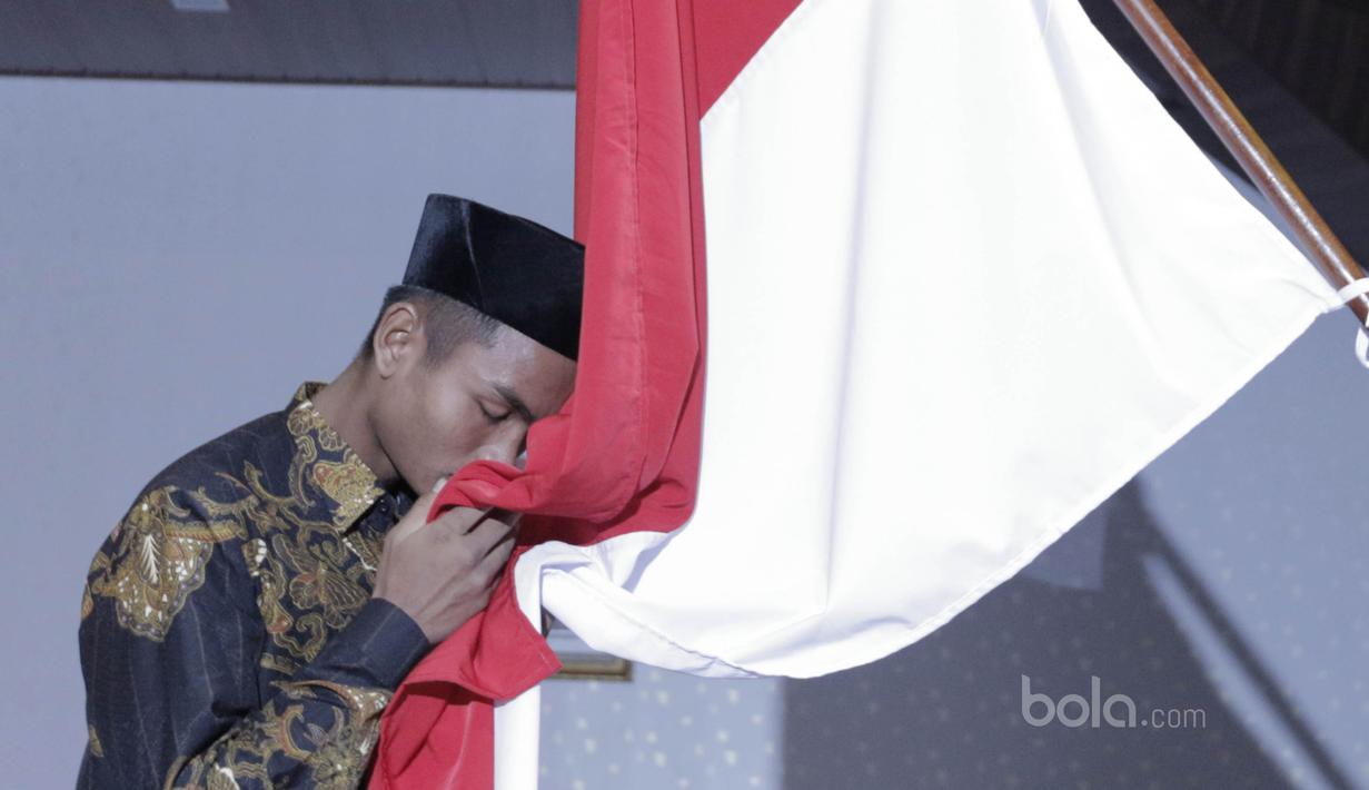 Pemain Timnas Indonesia U-16 mencium bendera Merah Putih saat acara pelepasan Timnas U-16 ke piala AFF di Jakarta, Kamis, (6/7/2017). Piala AFF U-15 akan berlangsung 9-22 Juli di Thailand. (Bola.com/M Iqbal Ichsan)