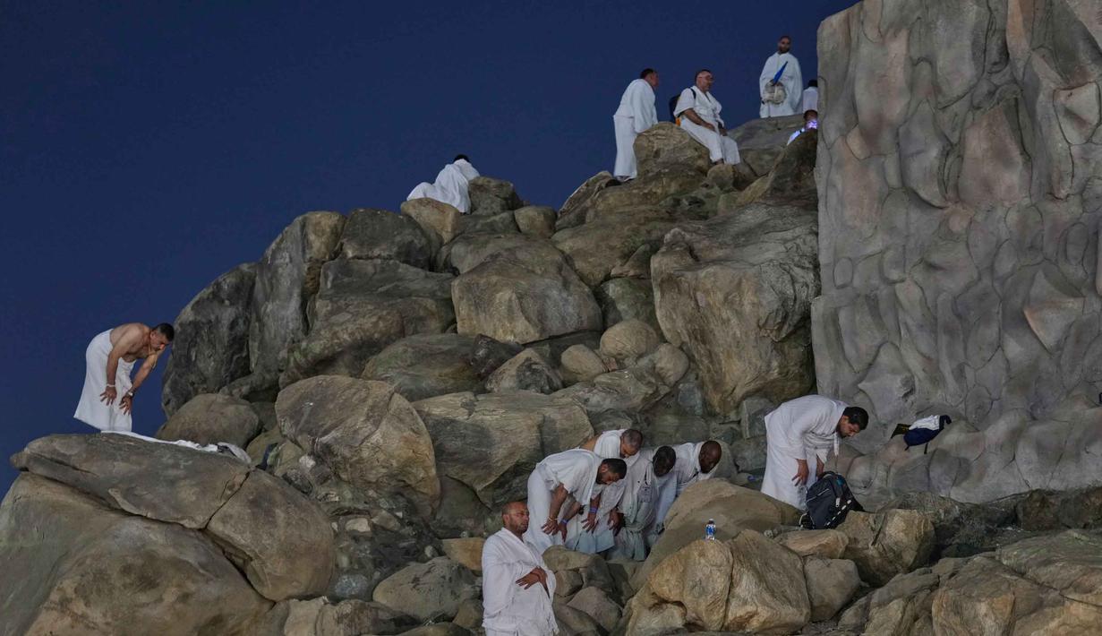 Umat Muslim menunaikan salat di puncak bukit berbatu yang dikenal sebagai Jabal Rahmah atau Gunung Rahmat, di Dataran Arafah, selama ibadah haji tahunan di dekat kota suci Mekah, Arab Saudi, Selasa 26 Mei 2026. (AP Photo/Altaf Qadri)