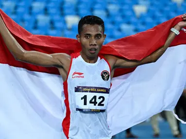 Pelari Indonesia Rikki Marthin Luther Simbolon merayakan kemenangannya pada final 10.000 m putra SEA Games 2023 di Phnom Penh, Kamboja, Kamis (11/5/2023). Rikki Marthin memenangkan pertandingan dengan catatan waktu 31 menit 8,85 detik. (MOHD RASFAN/AFP)