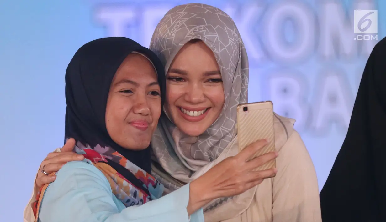 Peserta berswafoto dengan pemeran Ayat Ayat Cinta 2, Dewi Sandra pada acara Emtek Goes To Campus 2017 di Universitas Telkom, Bandung, Rabu (29/11). EGTC 2017 Bandung diadakan pada Selasa-Kamis, 28-30 November 2017. (Liputan6.com/Helmi Fithriansyah)