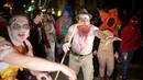 Sejumlah orang turun ke jalan dengan mengenakan kostum zombie saat mengikuti Zombie Walk dalam Festival Purim di Tel Aviv, Israel (3/3). Liburan Purim ini dirayakan dengan parade dan pesta kostum. (AP Photo/Ariel Schalit)