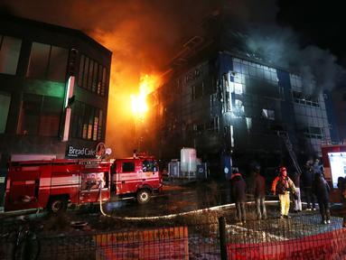 Petugas pemadam kebakaran berusaha memadamkan api yang melahap sebuah pusat kebugaran di kota Jecheon, Korea Selatan (Korsel), Kamis (21/12). Kebakaran besar itu menewaskan 29 orang dan menyebabkan puluhan lain terluka. (Kim Hyung-woo/Yonhap via AP)