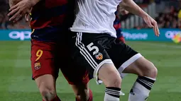 Bek Valencia, Shkodran Mustafi (depan) mengontrol bola dari kawalan penyerang Barcelona, Luis Suarez di pertandingan liga Spanyol di Camp Nou stadium, Spanyol (18/4). Valencia menang atas Barcelona dengan skor 2-1. (AFP PHOTO/ JOSEP LAGO)