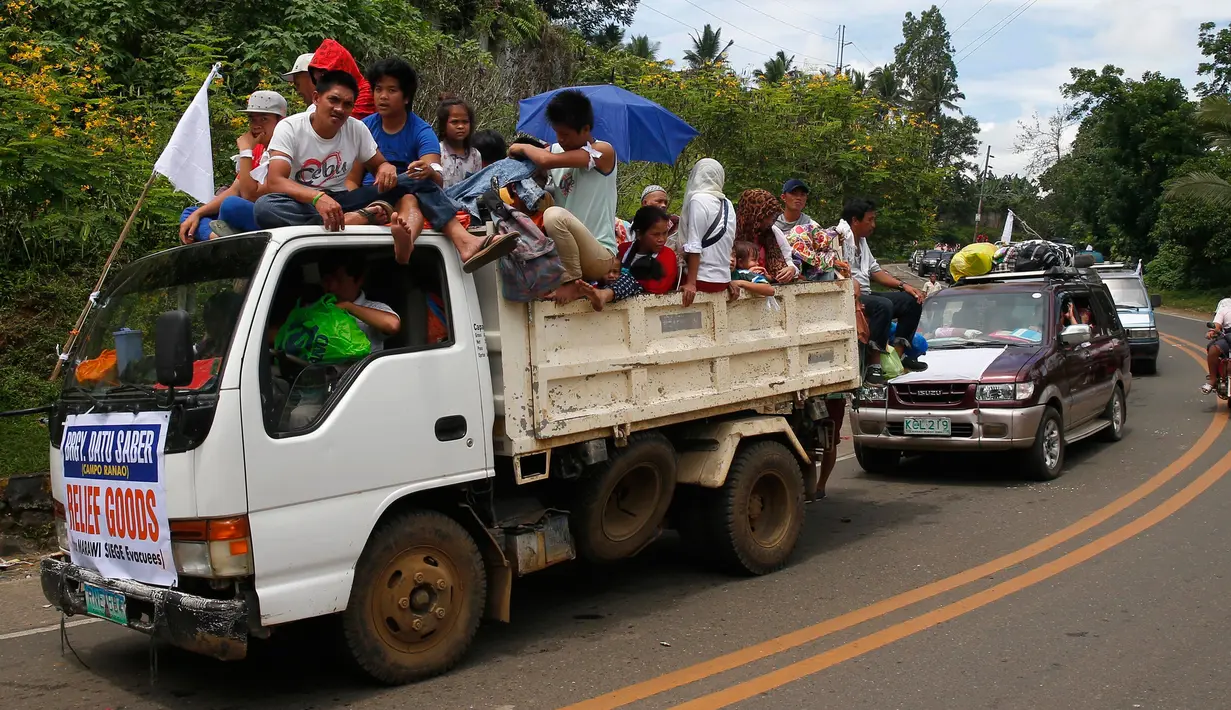 Sejumlah mobil membawa warga Marawi yang menyelamatkan diri dari pertempuran antara pasukan pemerintah dengan kelompok Maute, Filipina, Senin (29/5). Bendera putih dipasang agar mereka tidak diserang oleh pasukan pemerintah. (AP Photo / Bullit Marquez)