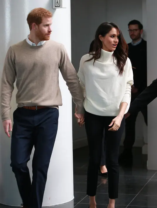 Pangeran Harry memengang tangan tunangannya Markle saat menghadiri sebuah acara yang diselenggarakan oleh perusahaan sosial Stemettes untuk merayakan Hari Perempuan Internasional di Millennium Point, Birmingham (8/3). (AFP Photo/Pool/Ian Vogler)