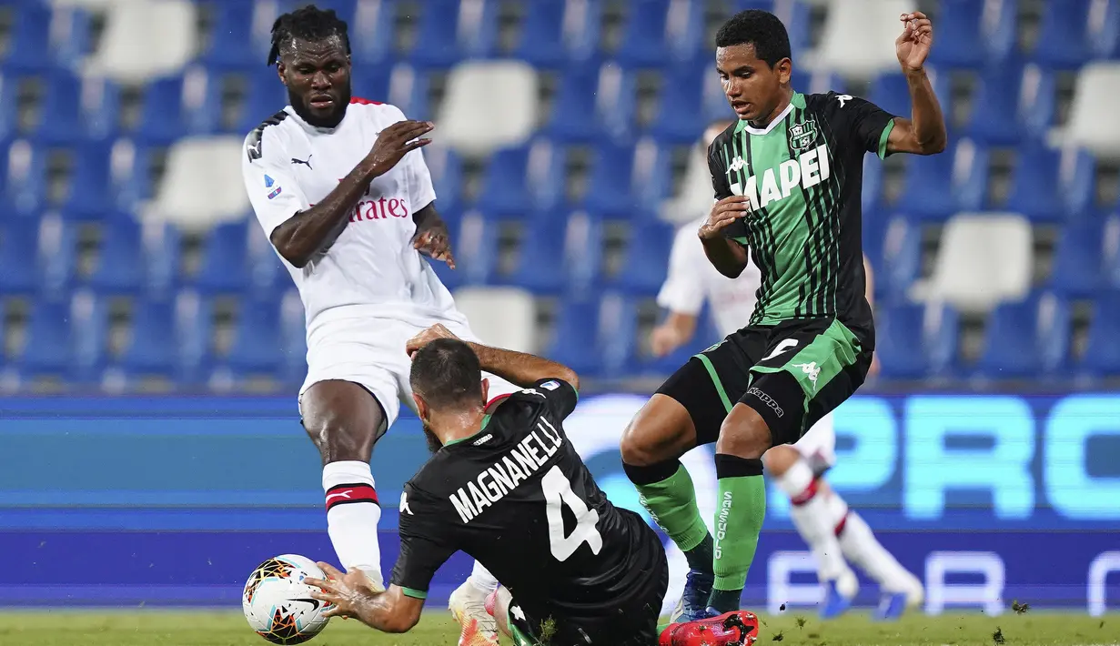 Pemain AC Milan Franck Kessie (kiri) dan pemain Sassuolo Rogerio (kanan) berebut bola pada pertandingan Serie A Italia di Stadion Mapei, Reggio Emilia, Italia, Selasa (21/7/2020). AC Milan menang 2-1 sekaligus menggeser posisi AS Roma dari posisi lima klasemen. (Spada/LaPresse via AP)